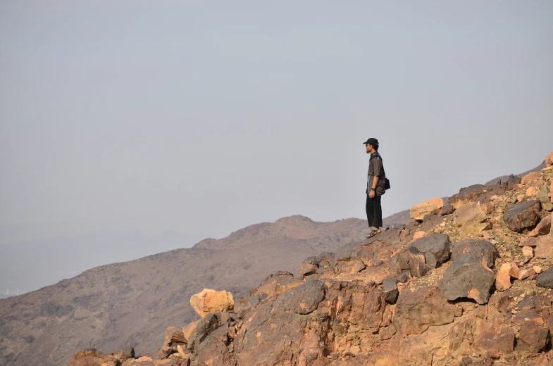 a man standing on top of a mountain above the rocks