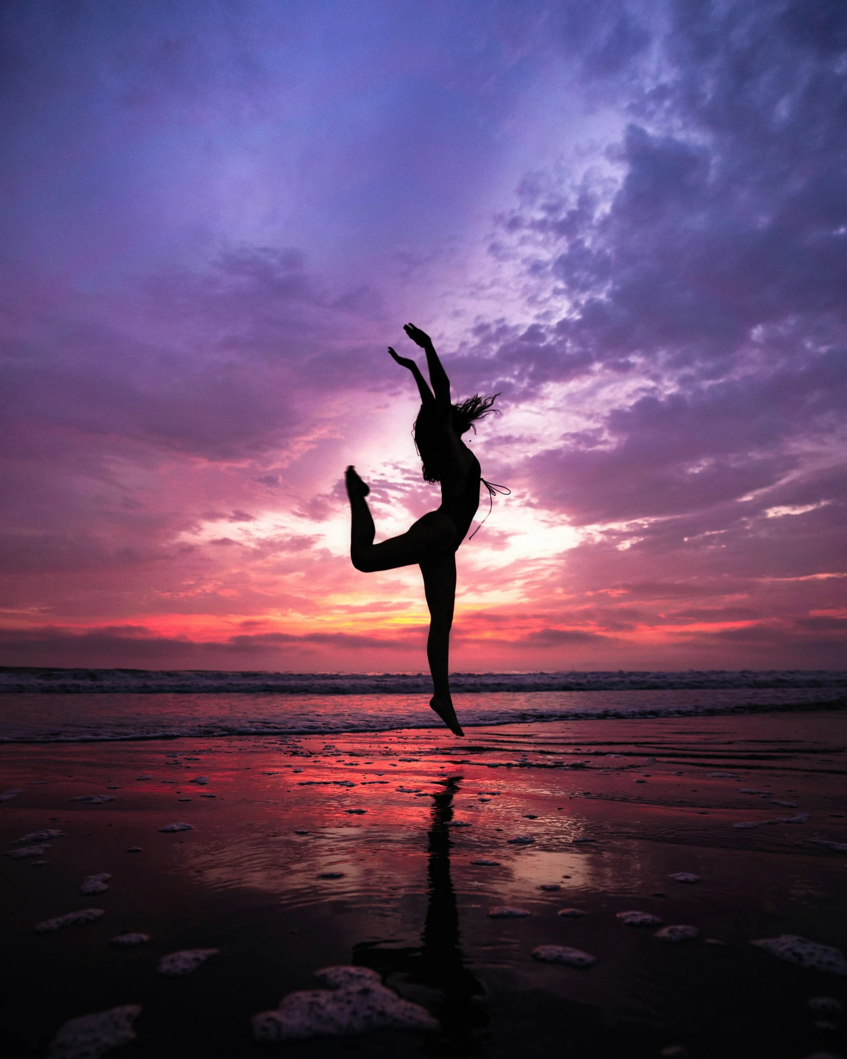 a silhouette of a dancer at sunset over the water