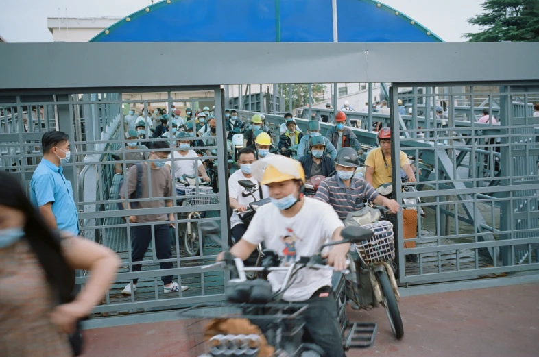 people are standing around while two men are riding a motorized bike