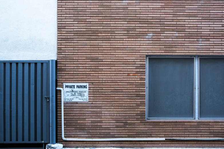 a black metal door near a brick wall