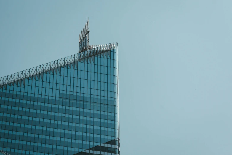 a tall building with a pointy roof has an airplane flying above