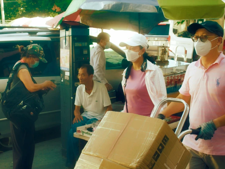 people wait with boxes to receive medical attention