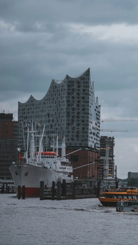 a cruise ship in the harbor near a large building