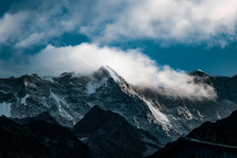 clouds cover the mountaintops in front of a house