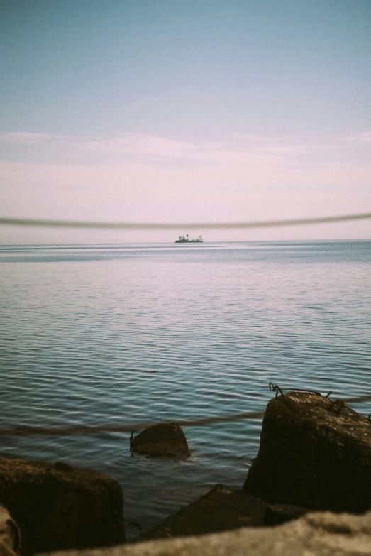 there is a lone boat in the water from rocks