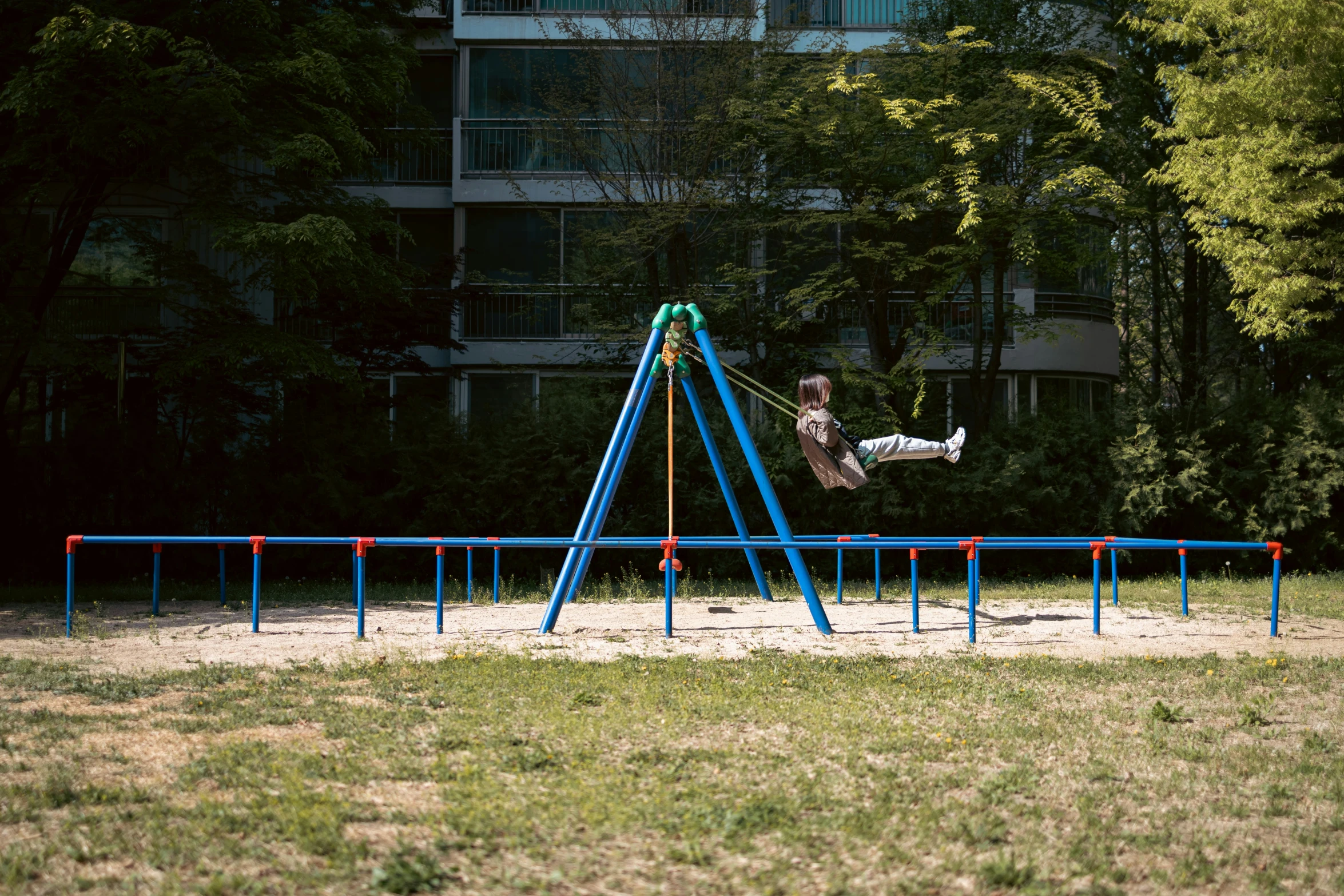 a young child swings on the swing set