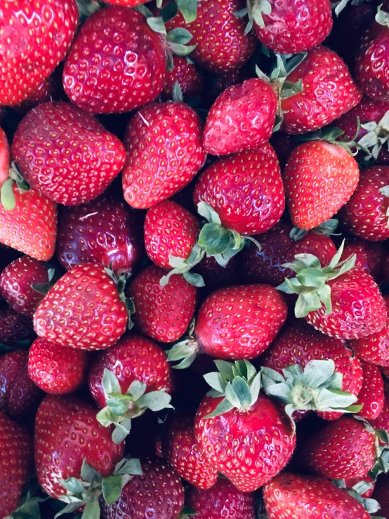 a lot of very ripe strawberries in a pile