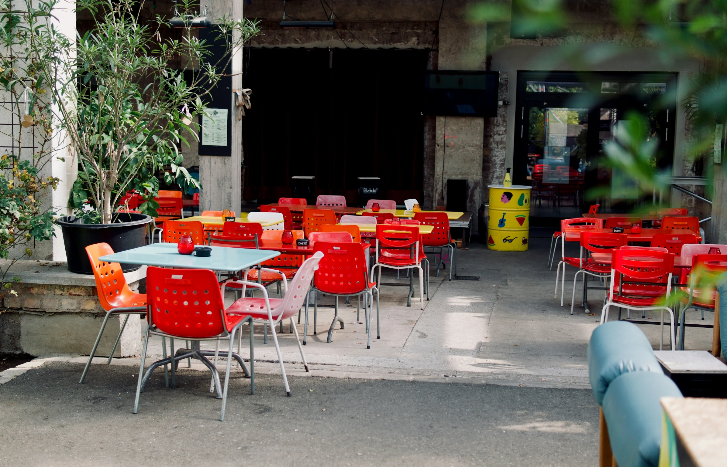 an outdoor restaurant with orange and red chairs