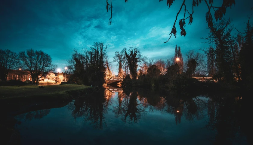 a lake with the water reflecting it with a building in the background