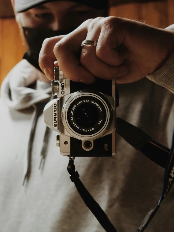 a man in grey sweatshirt holding onto a camera