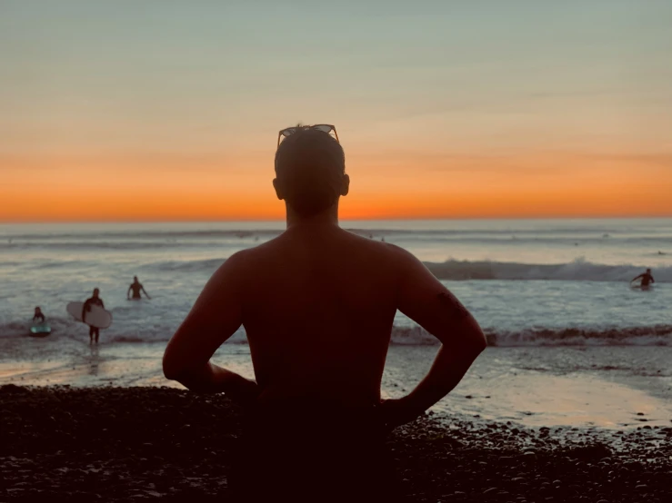 the back of a person sitting in front of the water