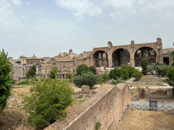 an old ruins and surrounding building are seen from across the area