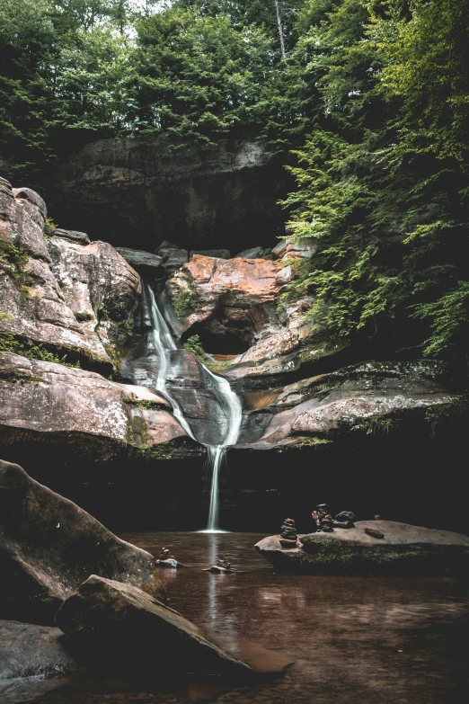 a waterfall flows through an area in the woods