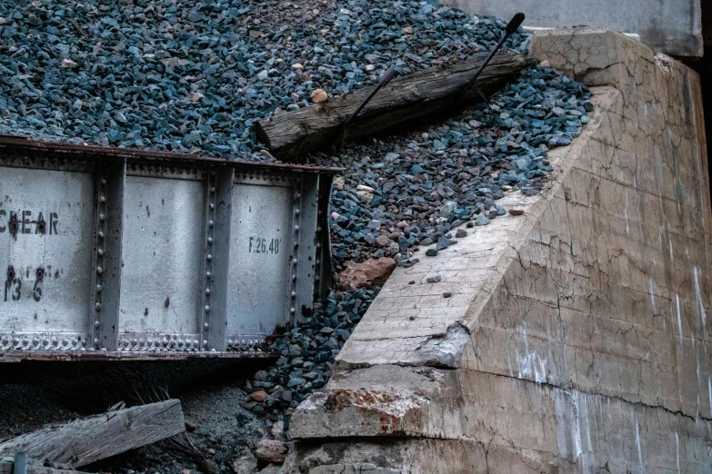 an old train car sits beside a pile of rocks