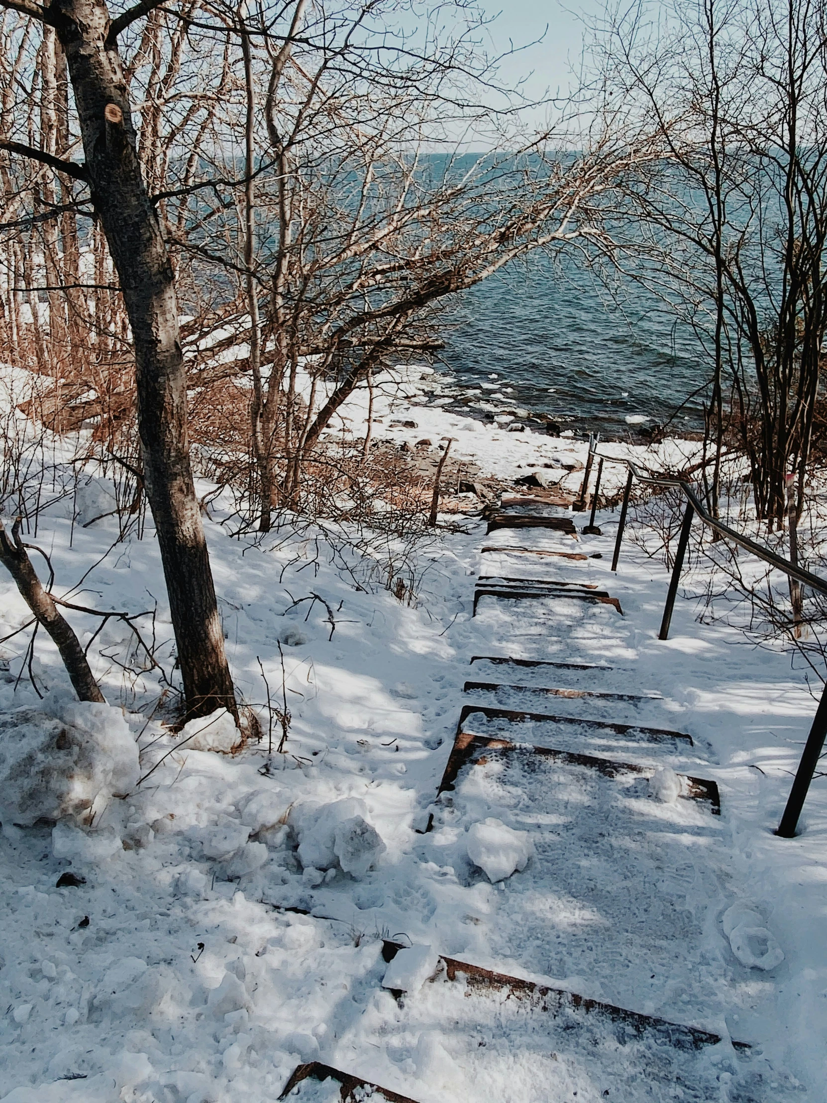 the snow covered steps lead to an ocean