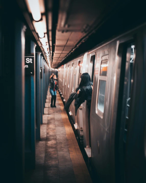 a couple of women are walking on a train platform