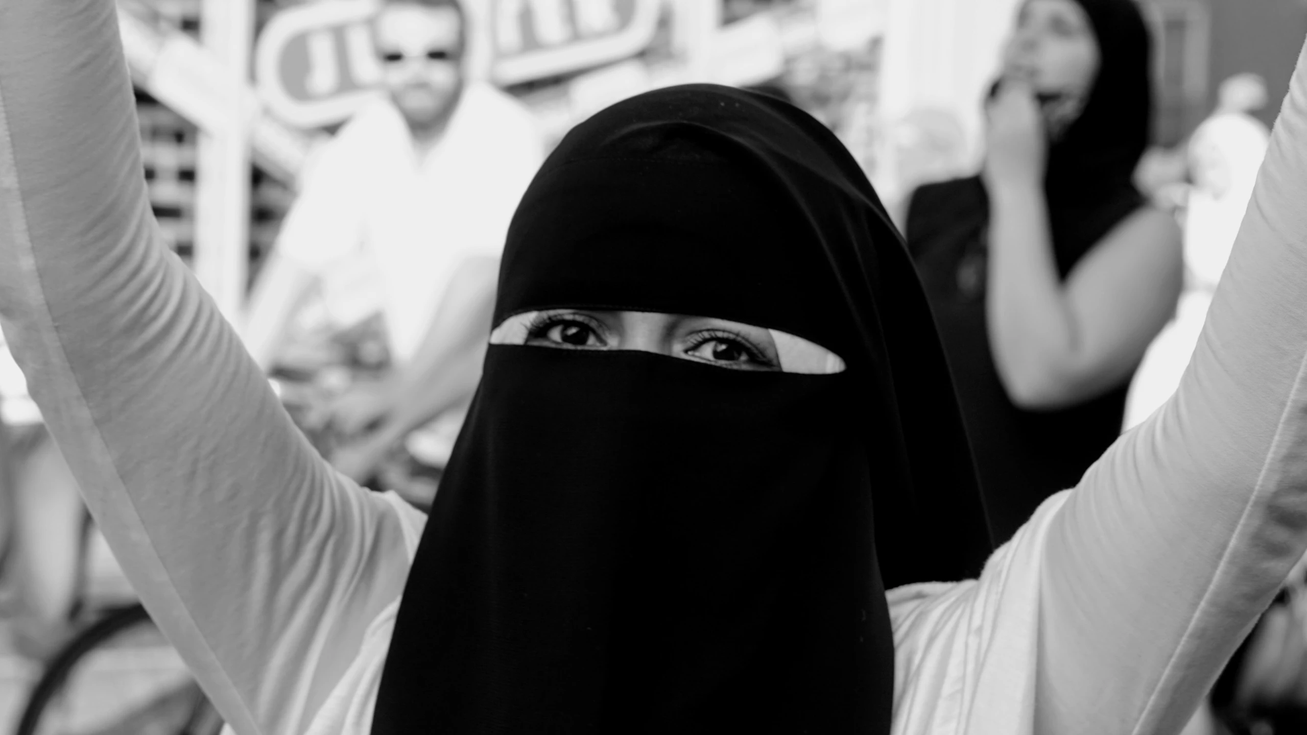 a woman in a black head covering holding a cell phone