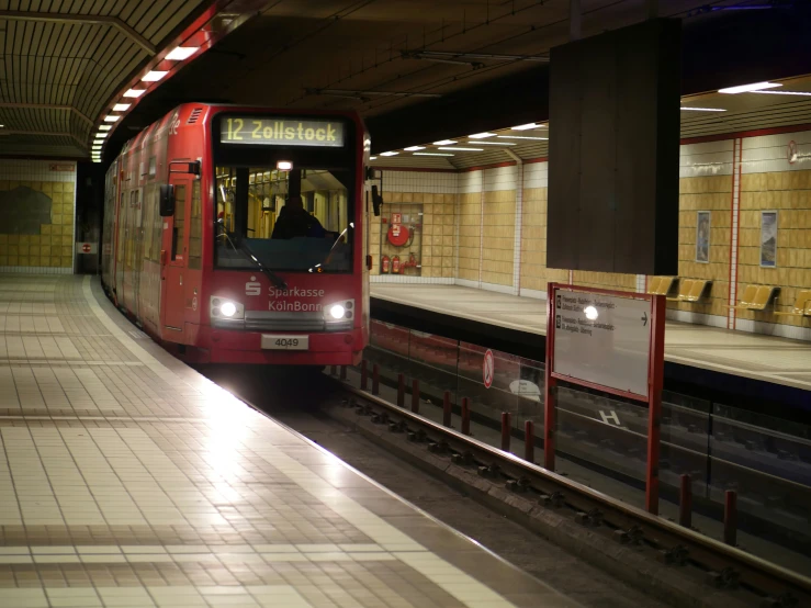 a red train sitting at the station where passengers can board