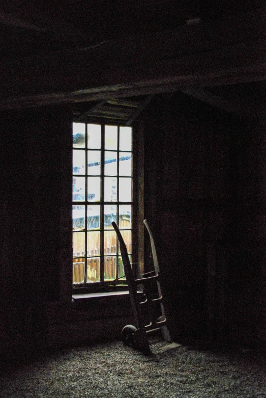 a rocking chair is standing near a window