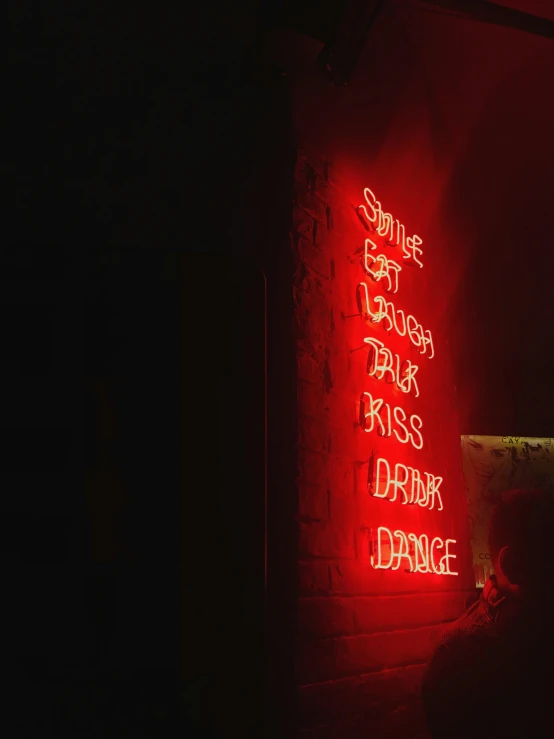 red neon signs above a dark brick wall