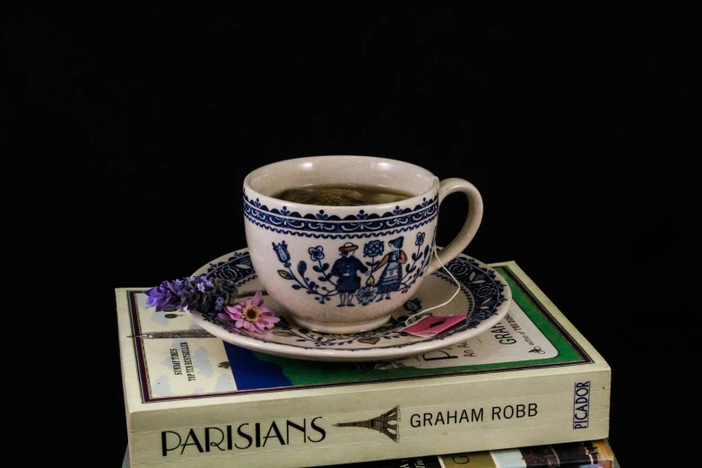 tea on a stack of three books on a table