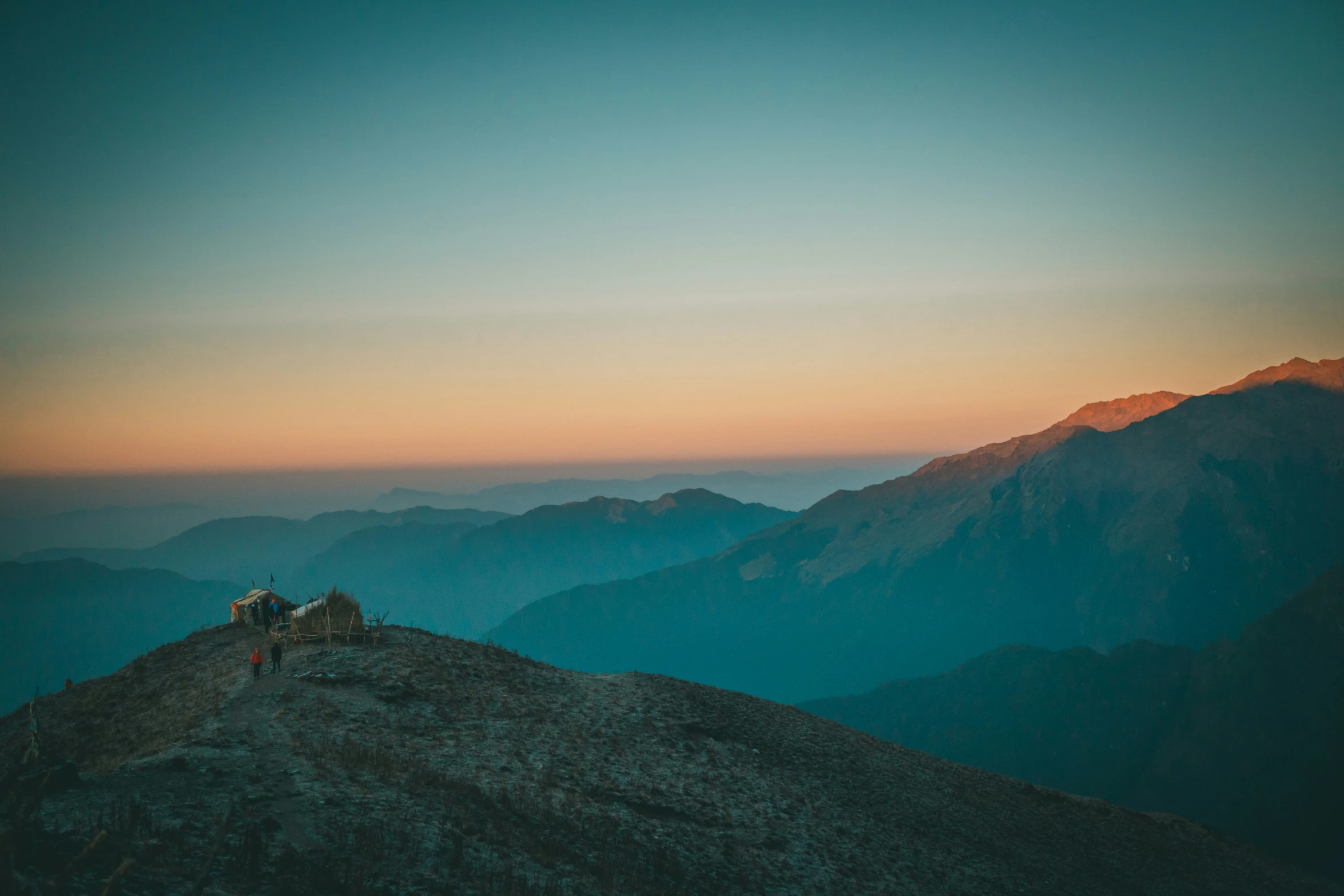 some people sitting on the top of a high mountain