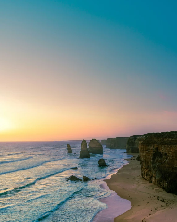 the ocean and rocks with a clear sky