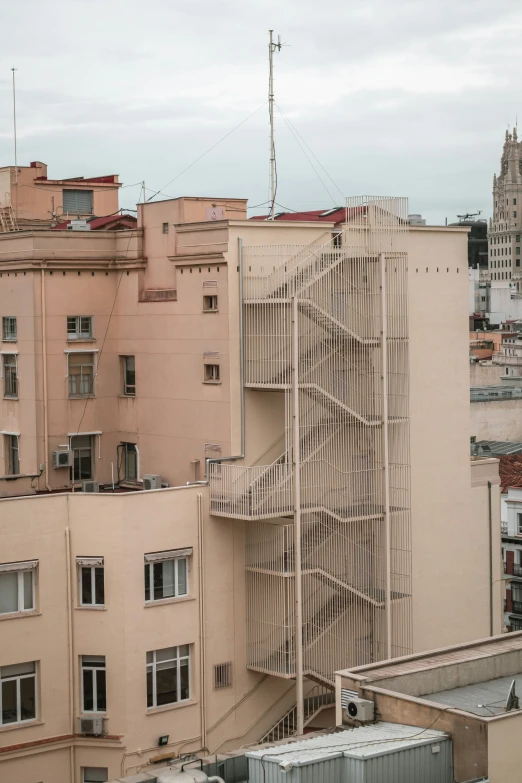 the view of a building with a tall spiral shaped staircase between two buildings