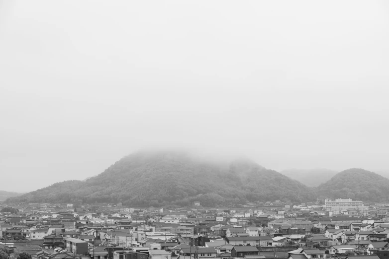 an aerial view of city with mountains in the background