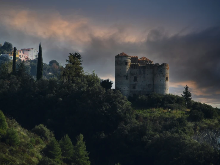 the large, stone castle stands high above the trees