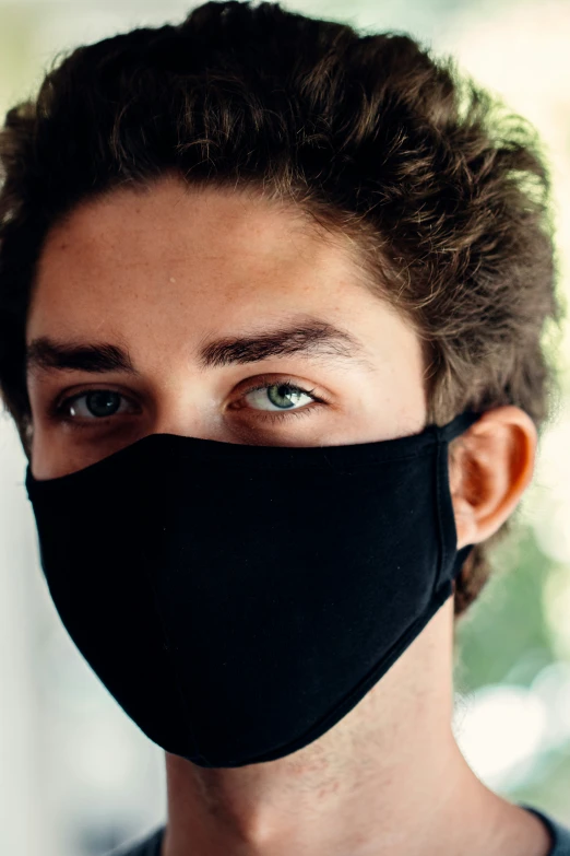 a man with a black face mask on looking up