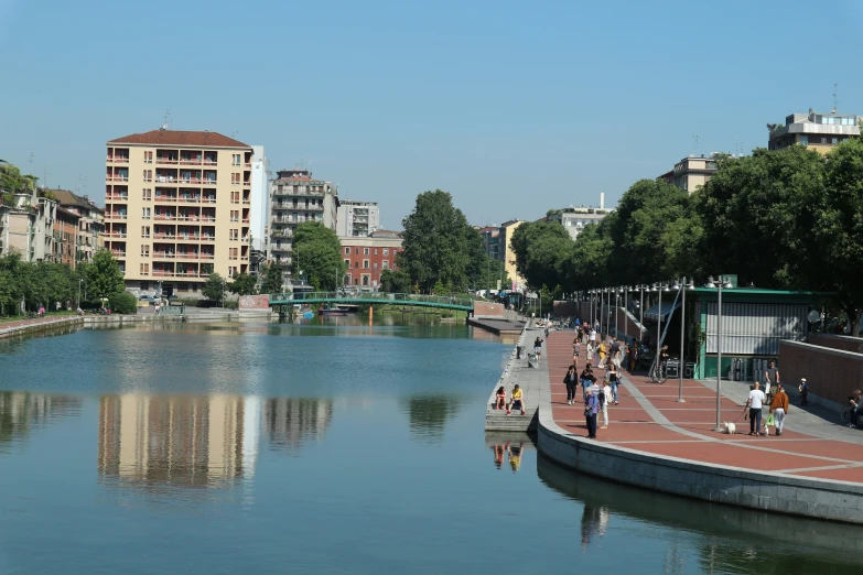 people strolling down the walkway along a river