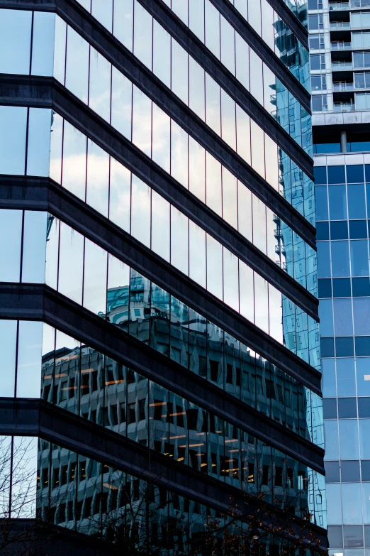 the reflection of the blue glass windows on a skyscr