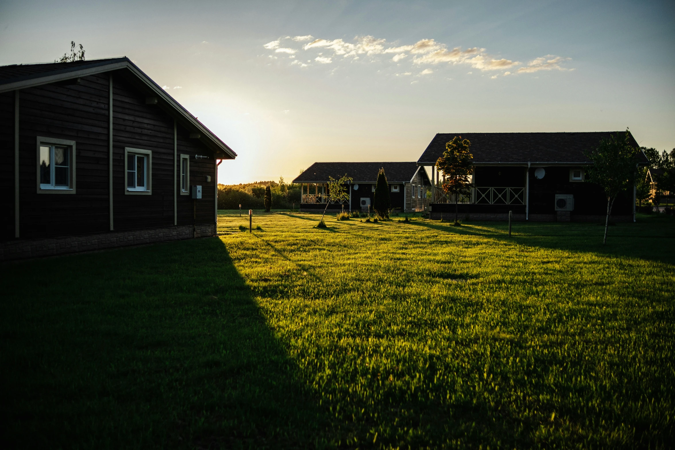 the sun shines on the houses and lawn