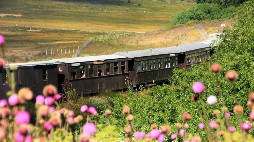 an old train car that is on tracks, coming over a hill