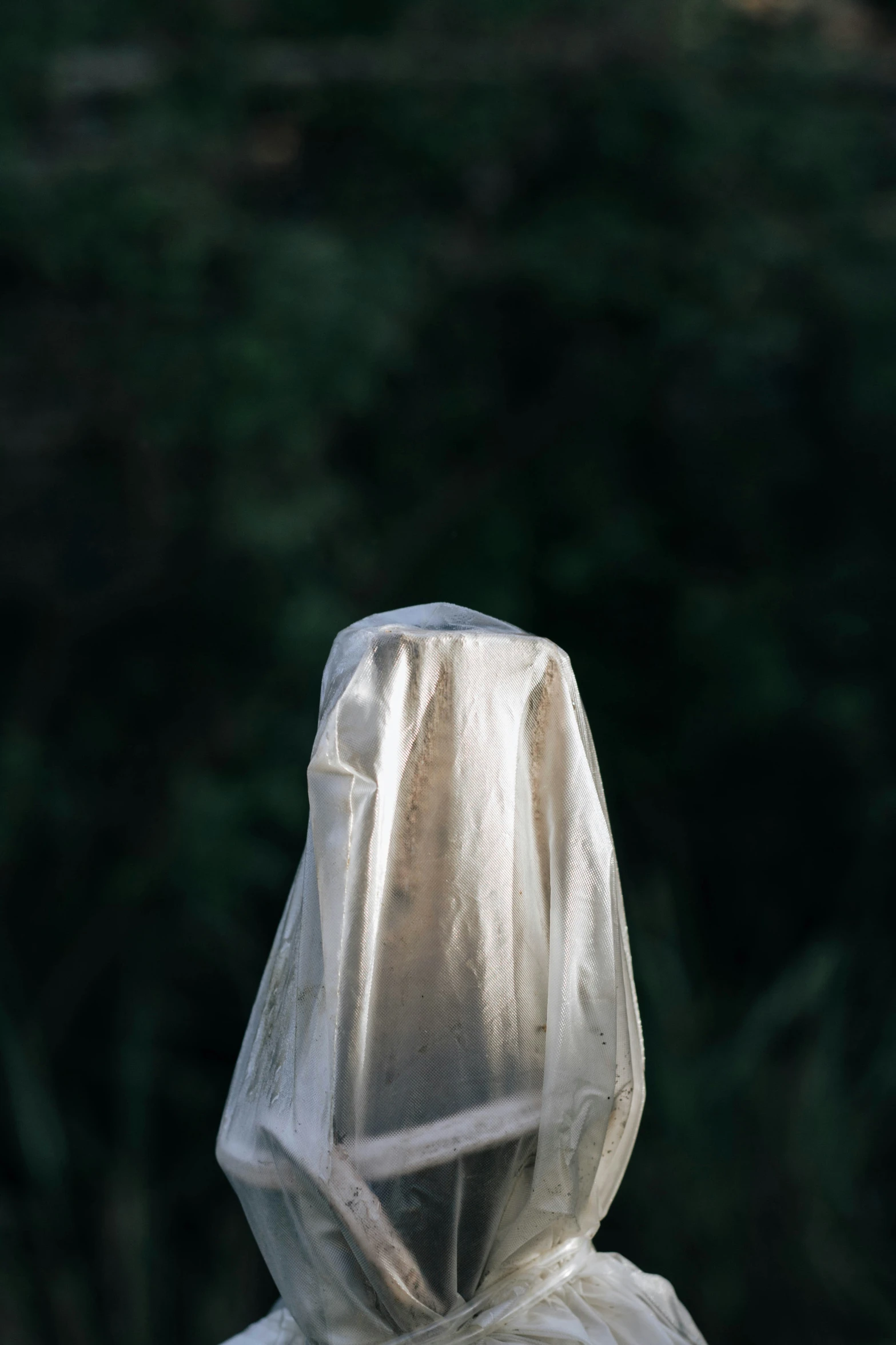 a white umbrella covered in plastic sitting on top of a wooden floor