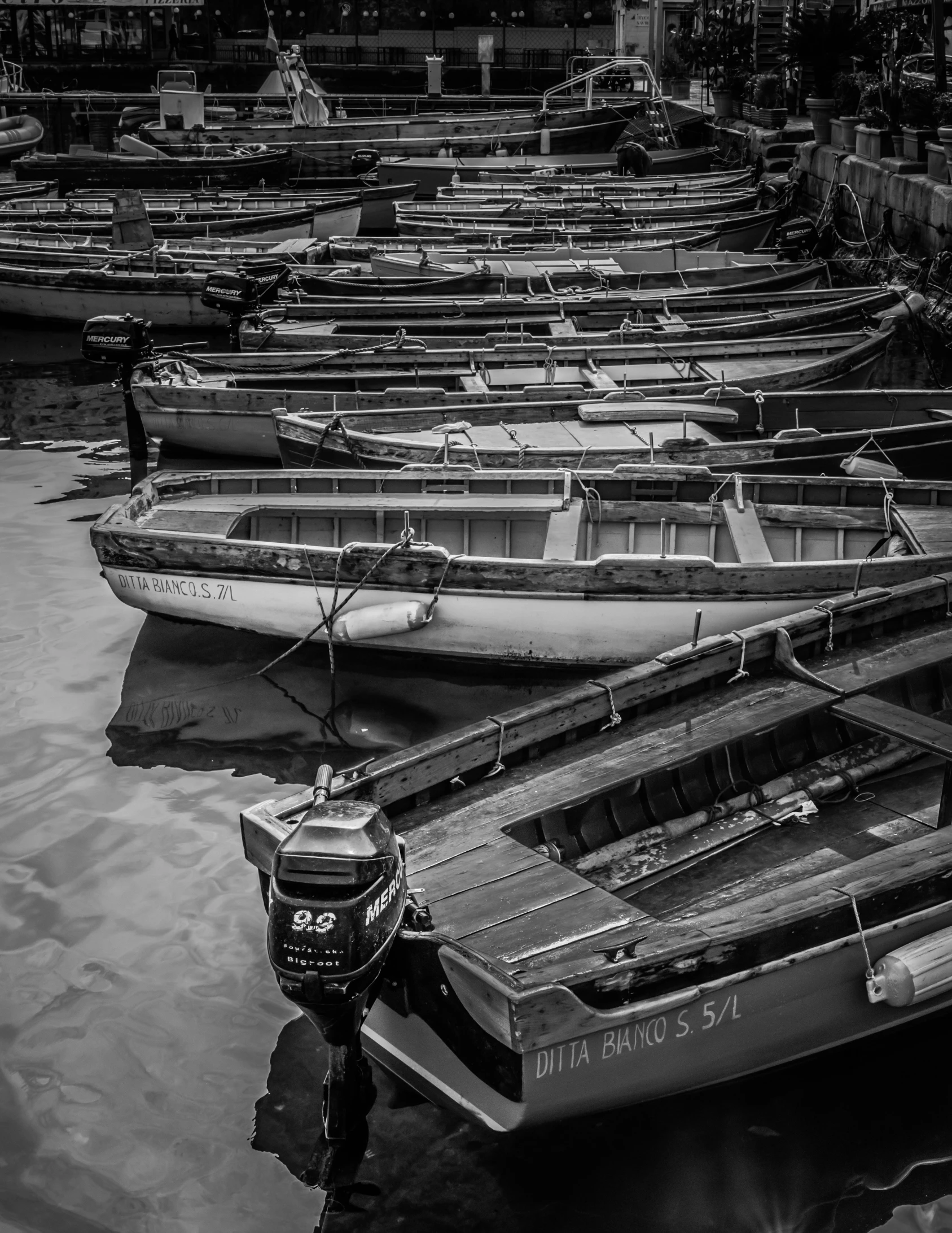 several boats docked at the pier while others float