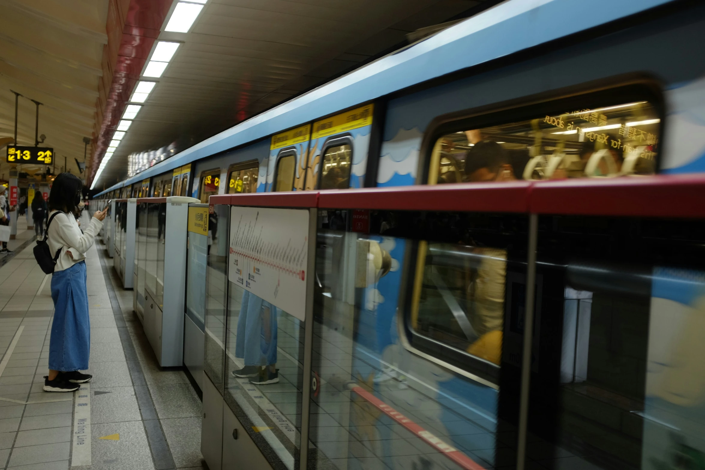 a woman is waiting at the station to board a train