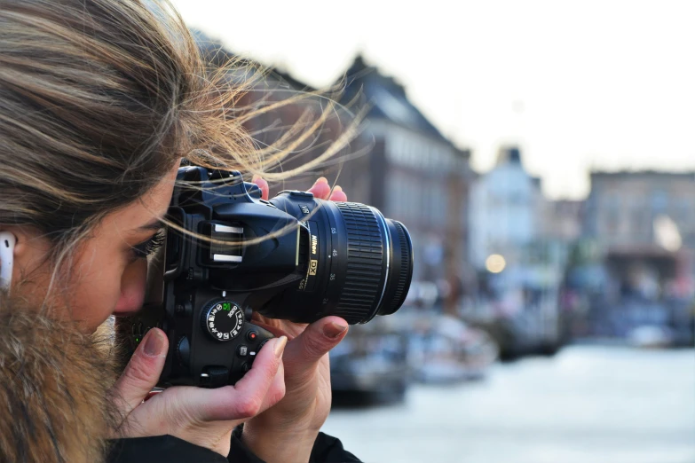 a woman holding a camera looking through the lens