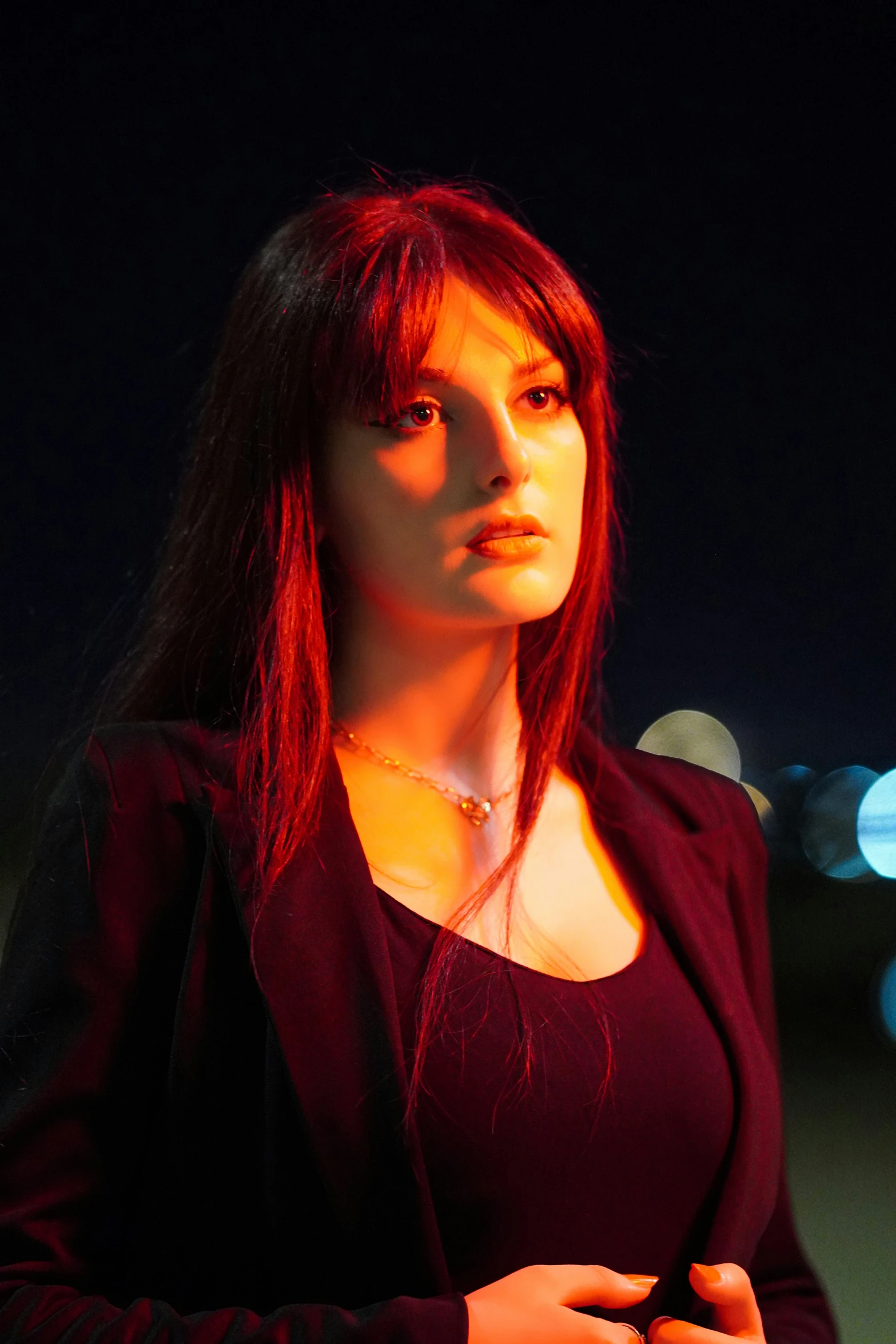 a woman in a red shirt is standing with a cell phone