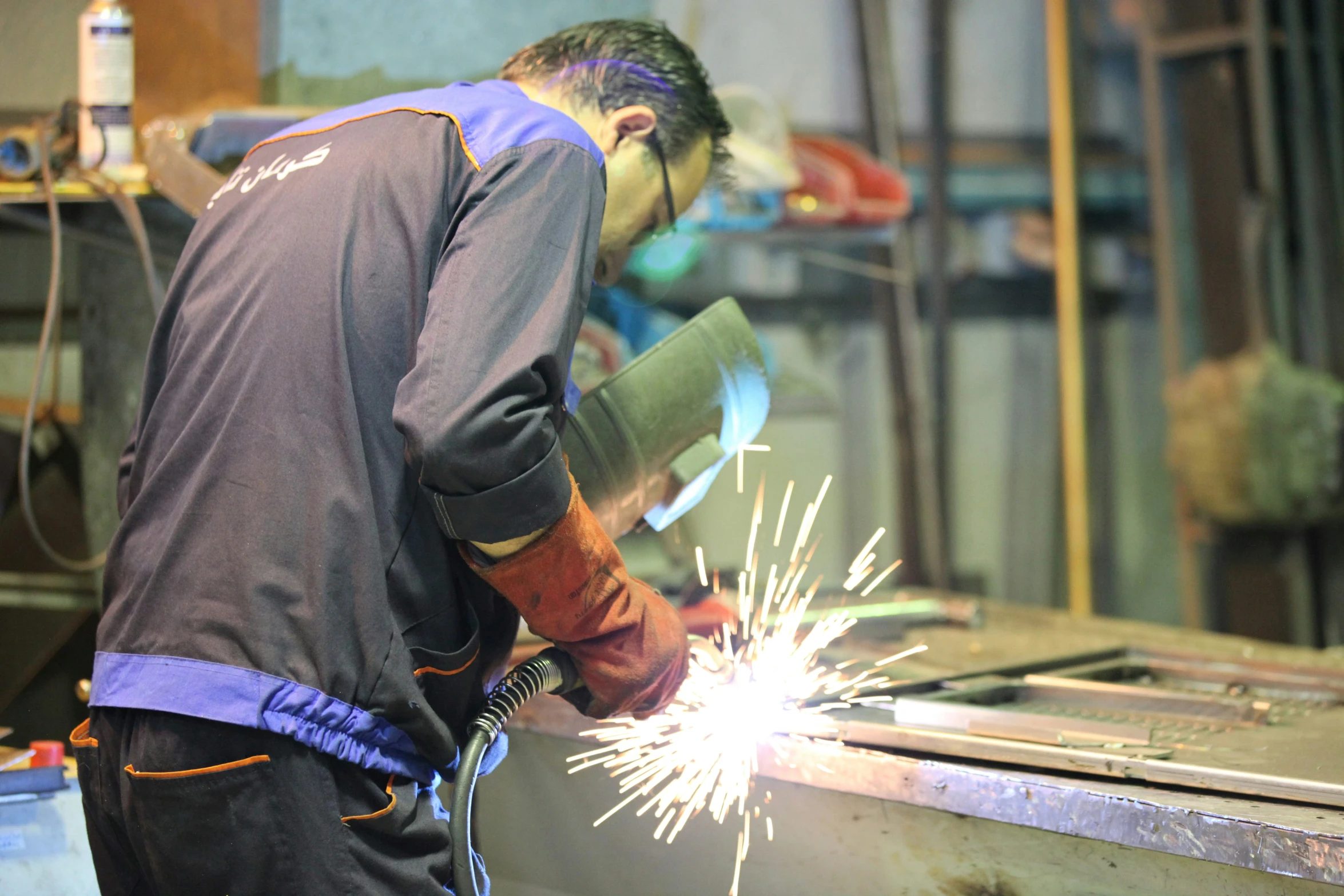 a man uses a welding tool in a metal shop