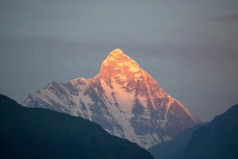 a very tall mountain with snow on it's sides