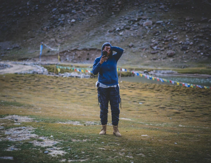 a man taking a po while wearing boots in the grass