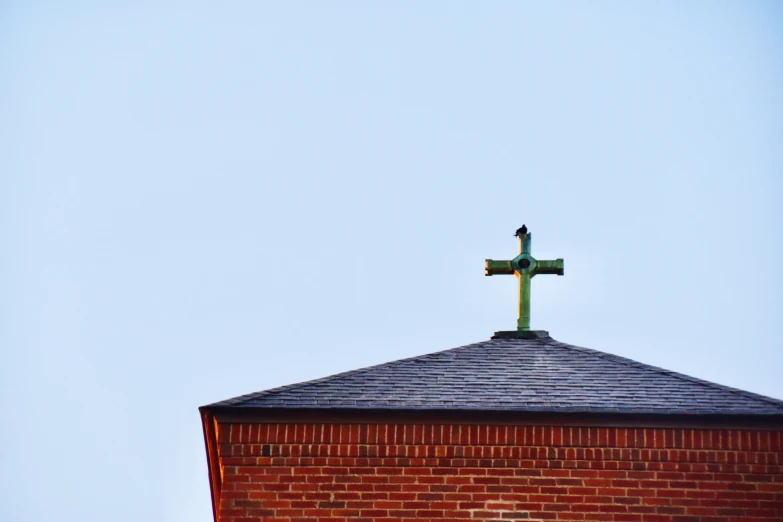 cross on the top of a red brick church