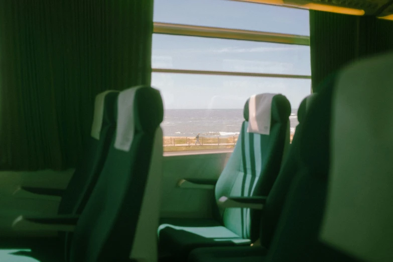 seats with curtains are facing a view of the ocean