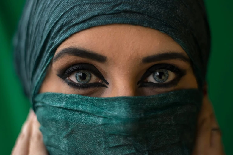 woman wearing green cloth covering her face