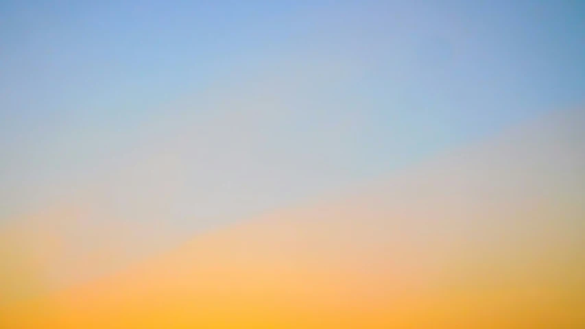 a kite flying through the sky at sunset