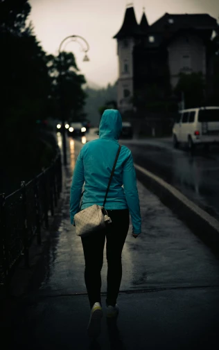 a person in blue jacket walking down sidewalk
