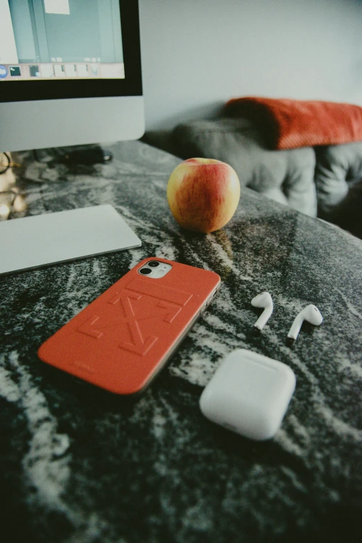 an apple laying on a table with earbuds