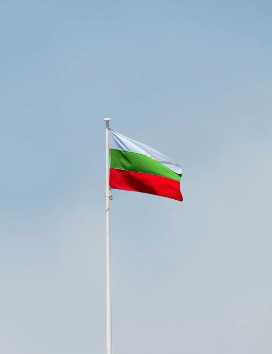 an italian and mexican flag flying high in the air